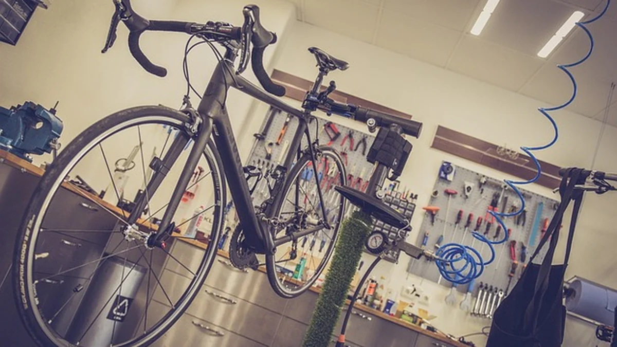 Taller ciclista con bicicleta y herramientas para revisar una compra usada